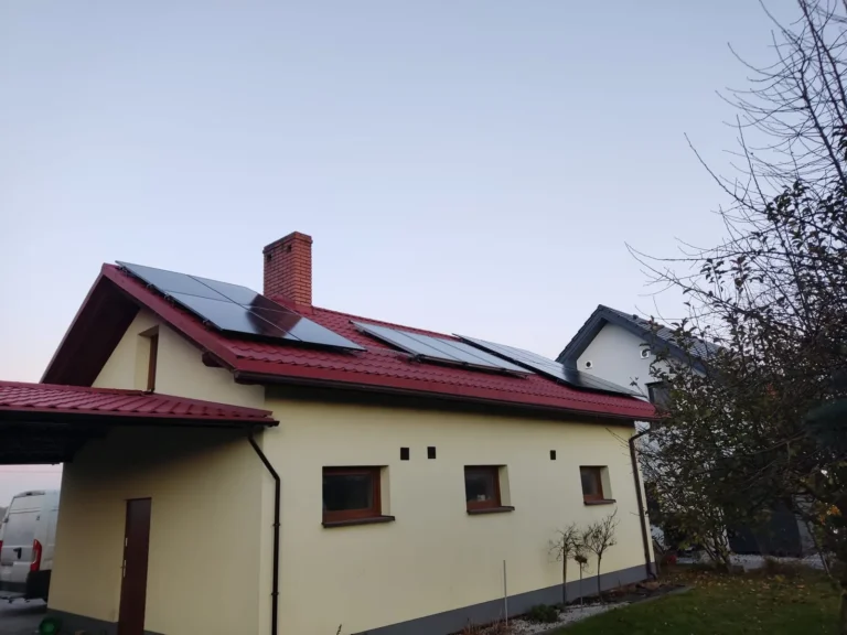 Panele fotowoltaiczne na czerwonym dachu budynku w Wilczy